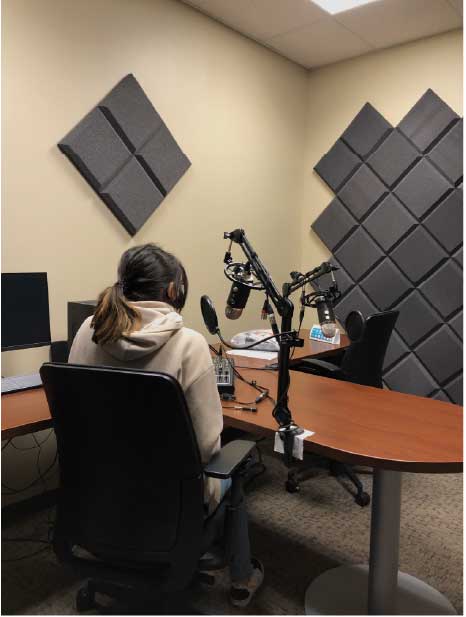 woman sitting at a desk in the audio production studio