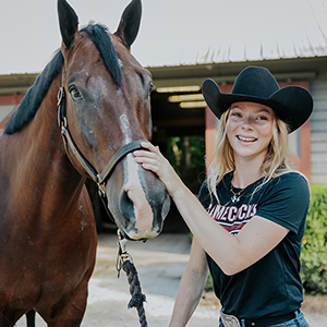 Ruby Voortmeyer poses with a brown horse.