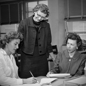 Ada B. Thomas surrounded by students at a table.
