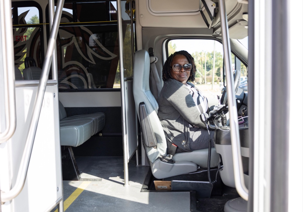 Kenyatta Green sits in the driver's seat of a USC transit bus.